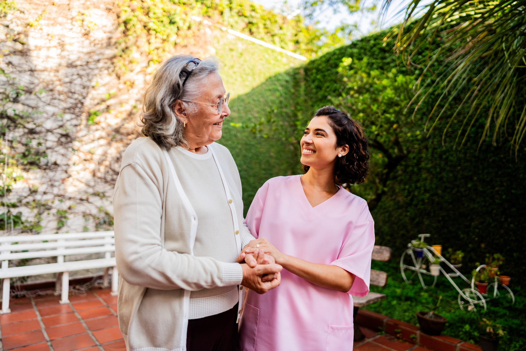 Senior woman walking with nurse at nursing home